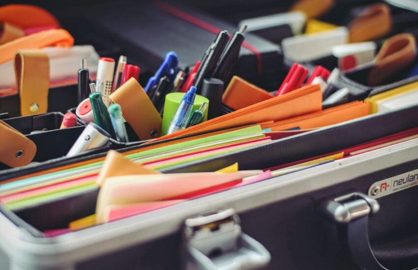 A collection of colorful office supplies neatly arranged in a suitcase, perfect for professionals on the go.