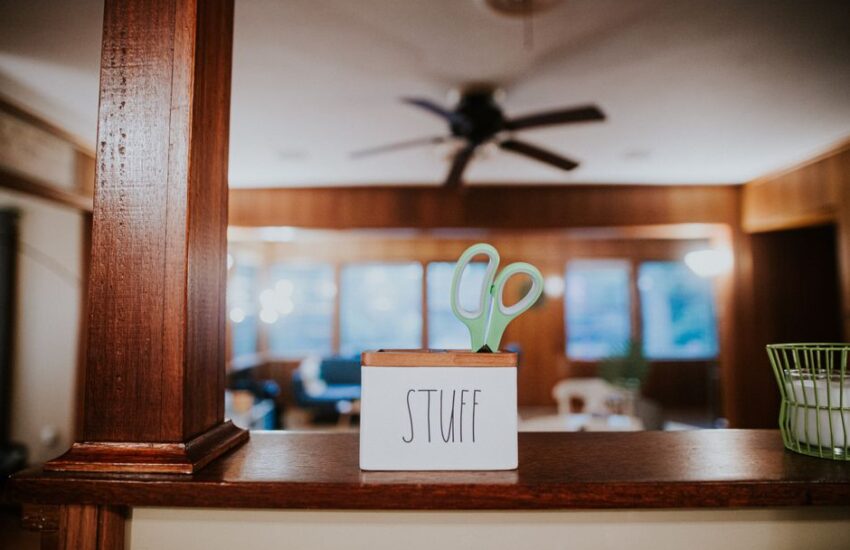 Scissors in small wooden box with handwritten word Stuff placed on counter in modern office