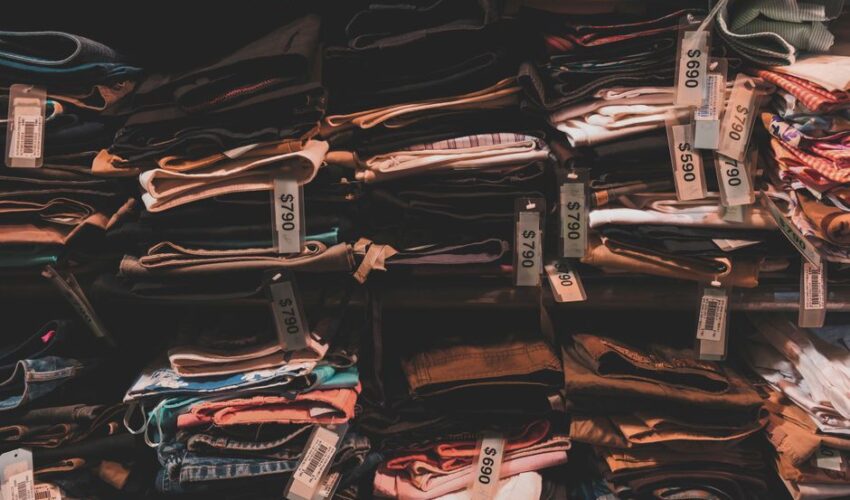 Neatly folded clothes with price tags on shelves in a Taipei shop.