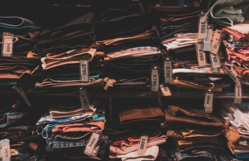 Neatly folded clothes with price tags on shelves in a Taipei shop.