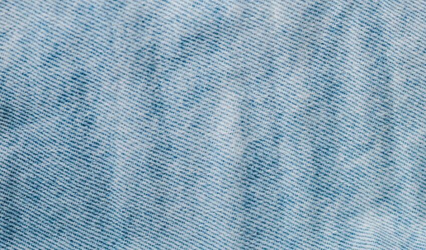 Detailed close-up of light blue denim fabric showcasing texture and weave pattern.